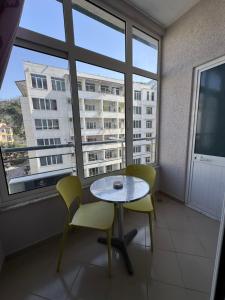 a room with a table and chairs and a large window at Mesdheu ApartHotel in Durrës