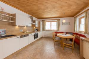 a kitchen and dining room with a table and chairs at Hinterbichlhof - Apartments in Viehhofen