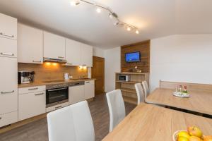 a kitchen and dining room with a table and chairs at Hinterbichlhof - Apartments in Viehhofen +18 photos