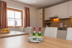 a kitchen with a table with two bottles of wine at Hinterbichlhof - Apartments in Viehhofen