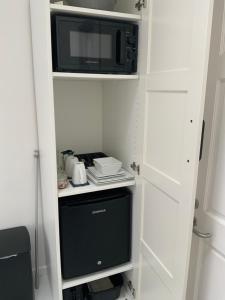 a small kitchen with a microwave and a refrigerator at Double Bedroom with Private Entrance in Weymouth