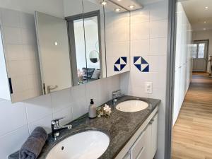 a bathroom with two sinks and a mirror at Casa Rondinella by fewotessin in Orselina +22 photos