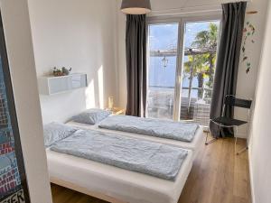 two beds in a bedroom with a view of the ocean at Casa Rondinella by fewotessin in Orselina
