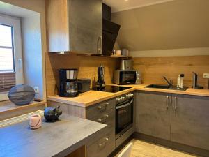 a kitchen with a sink and a stove top oven at Wohnung Burghaus 3 OG in Krummhörn