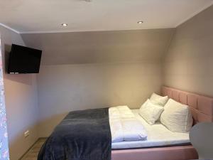 a bedroom with a bed with a tv on the wall at Wohnung Burghaus 3 OG in Krummhörn