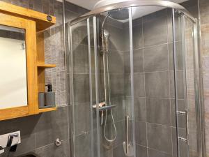 a shower with a glass door in a bathroom at Wohnung Burghaus 3 OG in Krummhörn +14 photos