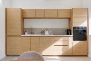 a kitchen with wooden cabinets and a sink at La Maison Léoncine in Allonnes
