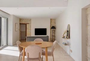 a dining room with a wooden table and chairs at La Maison Léoncine in Allonnes