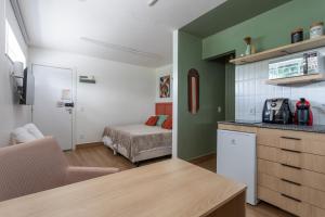 a room with a kitchen and a bedroom with a bed at Studio Andorinhas in Brasília