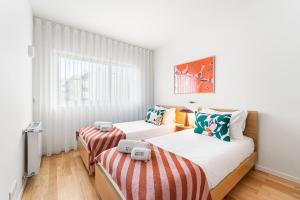 a bedroom with two beds and a window at GuestReady - Menéres Apartments in Matosinhos
