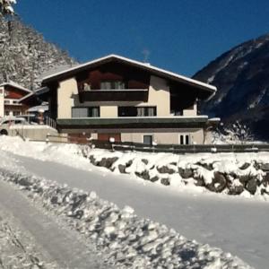 een huis in de sneeuw naast een weg bij Haus Herma in Bach