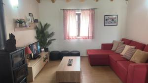 a living room with a red couch and a tv at Casa do Ti Chico in São Luis