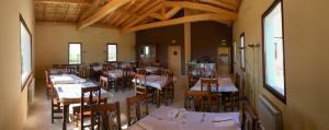 a restaurant with tables and chairs in a room at Albergue La Perala in Bercianos del Real Camino +12 photos