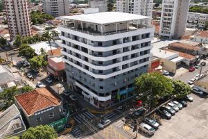 an overhead view of a tall white building in a city at Quitinete inteligente Centro da Cidade Unidade 1 in Presidente Prudente