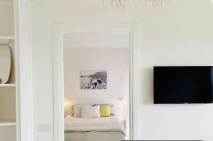 a white room with a bed and a tv at Como Lake Dreamscape Villa in Cernobbio