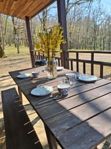 a wooden table with a vase of flowers on it at Domaine de Grézelou in Saint-Martial-de-Nabirat
