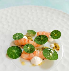 a plate of food with shrimp and green leaves at BLUE Airuno in Airuno