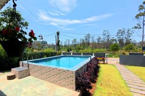 a swimming pool in a yard with a brick wall at Akshayaam Villa in Kotagala