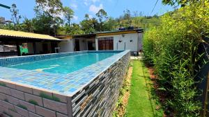 a swimming pool in a yard next to a house at Akshayaam Villa in Kotagala
