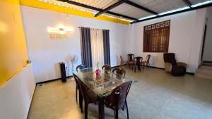 a dining room with a glass table and chairs at Akshayaam Villa in Kotagala