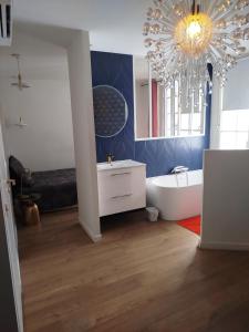 a bathroom with a tub and a chandelier at Superbe appartement en hyper centre avec clim in Toulouse +7 photos