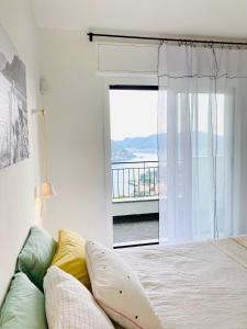 a bedroom with a bed and a large window at Como Lake Dreamscape Villa in Cernobbio