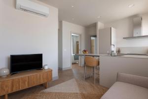 a living room with a television and a kitchen at Apartamentos Boutique Casco Histórico in Las Lagunas