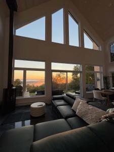 a large living room with a couch and large windows at Chalet Le Valkea - Spa & Mountain in Saint Come