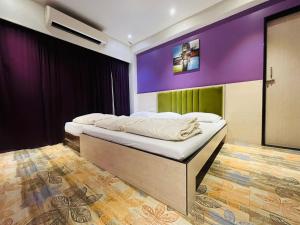 a bedroom with two beds and a purple wall at HOTEL MADNI ROYALE (50 Mtrs from Dargaah), Ajmer in Ajmer +57 photos