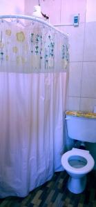 a bathroom with a white shower curtain and a toilet at Cabañas la calma in Concordia +19 photos