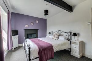 a bedroom with a bed with a purple wall at 2 Bed in Skipton oc-ds221 in Skipton