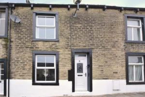 a brick building with a white door and windows at 2 Bed in Skipton oc-ds221 in Skipton +3 photos