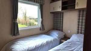 two beds in a small room with a window at Chalet 91 Retro in Westerland