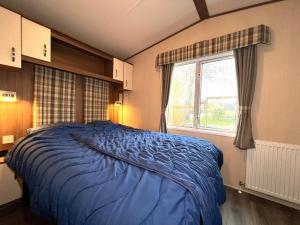 a bedroom with a blue bed and a window at Chalet 91 Retro in Westerland