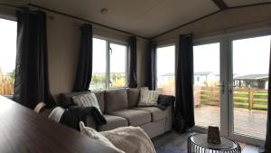 a living room with a couch and large windows at Chalet 91 Retro in Westerland +2 photos
