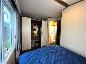 a bedroom with a blue bed and a window at Chalet 91 Retro in Westerland