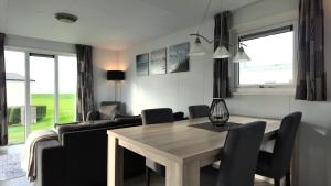 a living room with a dining room table and chairs at Chalet 6 Wellenruh in Westerland