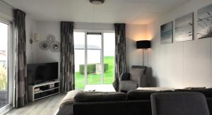a living room with a couch and a television at Chalet 6 Wellenruh in Westerland