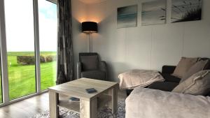 a living room with a couch and a table and a window at Chalet 6 Wellenruh in Westerland