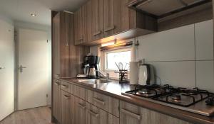 a kitchen with a stove and a sink and a window at Chalet 6 Wellenruh in Westerland +4 photos