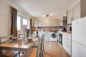 a kitchen with a wooden table and a kitchen with white appliances at 5 Bed in Chedgrave oc-twcg in Chedgrave