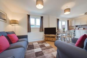 a living room with two blue couches and a kitchen at 5 Bed in Chedgrave oc-twcg in Chedgrave