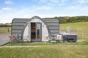 a small shed with a table and chairs in a field at 1 Bed in Cross oc-s29656 in Axbridge +5 photos