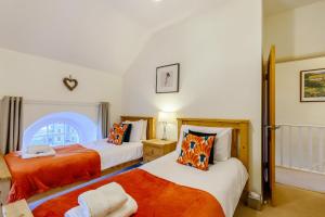 a bedroom with two beds with orange sheets at 3 Bed in Bainbridge oc-c28300 in Bainbridge