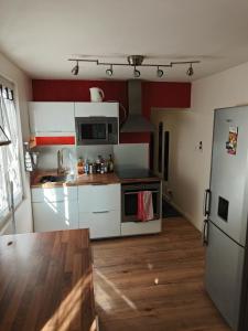 a kitchen with white cabinets and a wooden floor at Small townhouse in Clermont-Ferrand