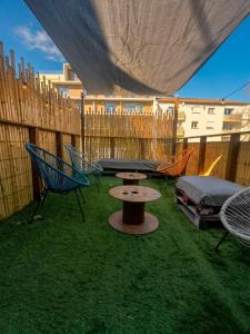 a patio with a picnic table and chairs and a fence at Small townhouse in Clermont-Ferrand
