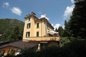 a yellow building with an umbrella on top of it at Hotel Valganna - Tre Risotti in Valganna