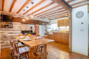a kitchen with a wooden table and a clock on the wall at 2 Bed in Penmaenpool oc-p32333 in Penmaenpool