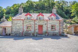 an old stone house with a red door at 2 Bed in Penmaenpool oc-p32333 in Penmaenpool