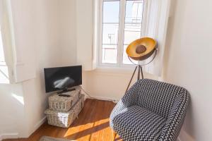 uma sala de estar com uma cadeira e uma televisão em LovelyStay - Cosy Bairro Alto Duplex em Lisboa